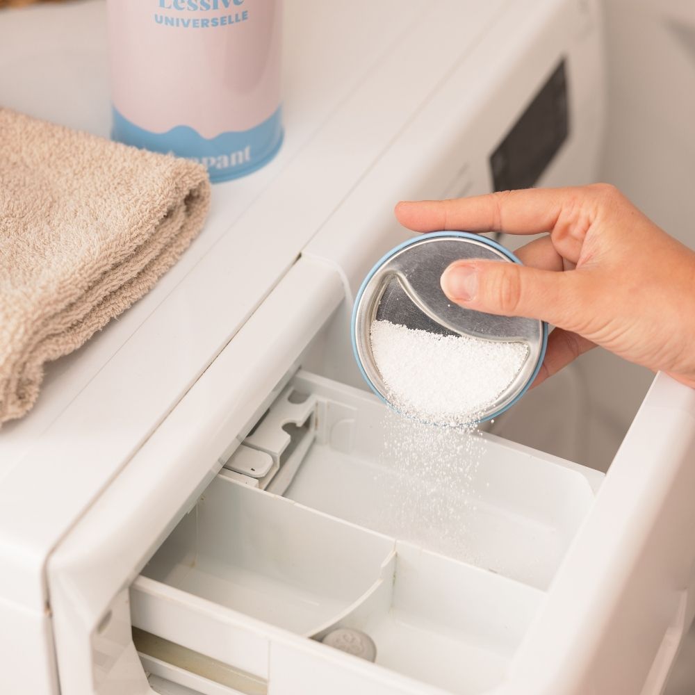 Pouring a dose of Pimpant laundry powder into the washing machine